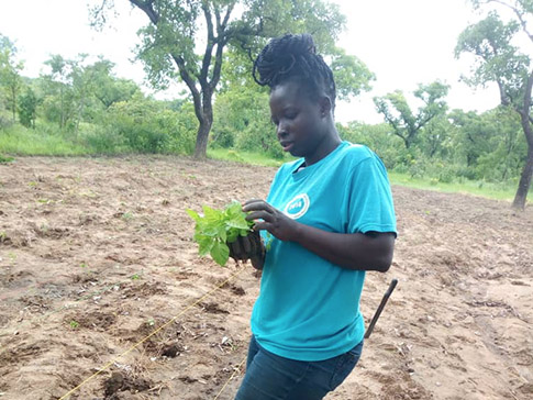 Olivia planting crops at her farm