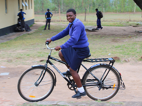 Aneni riding her bicycle to school Aneni riding her bicycle to school