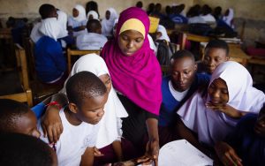 Learner Guide Zuhura Ally helping group of secondary students in a classroom in Tanzania