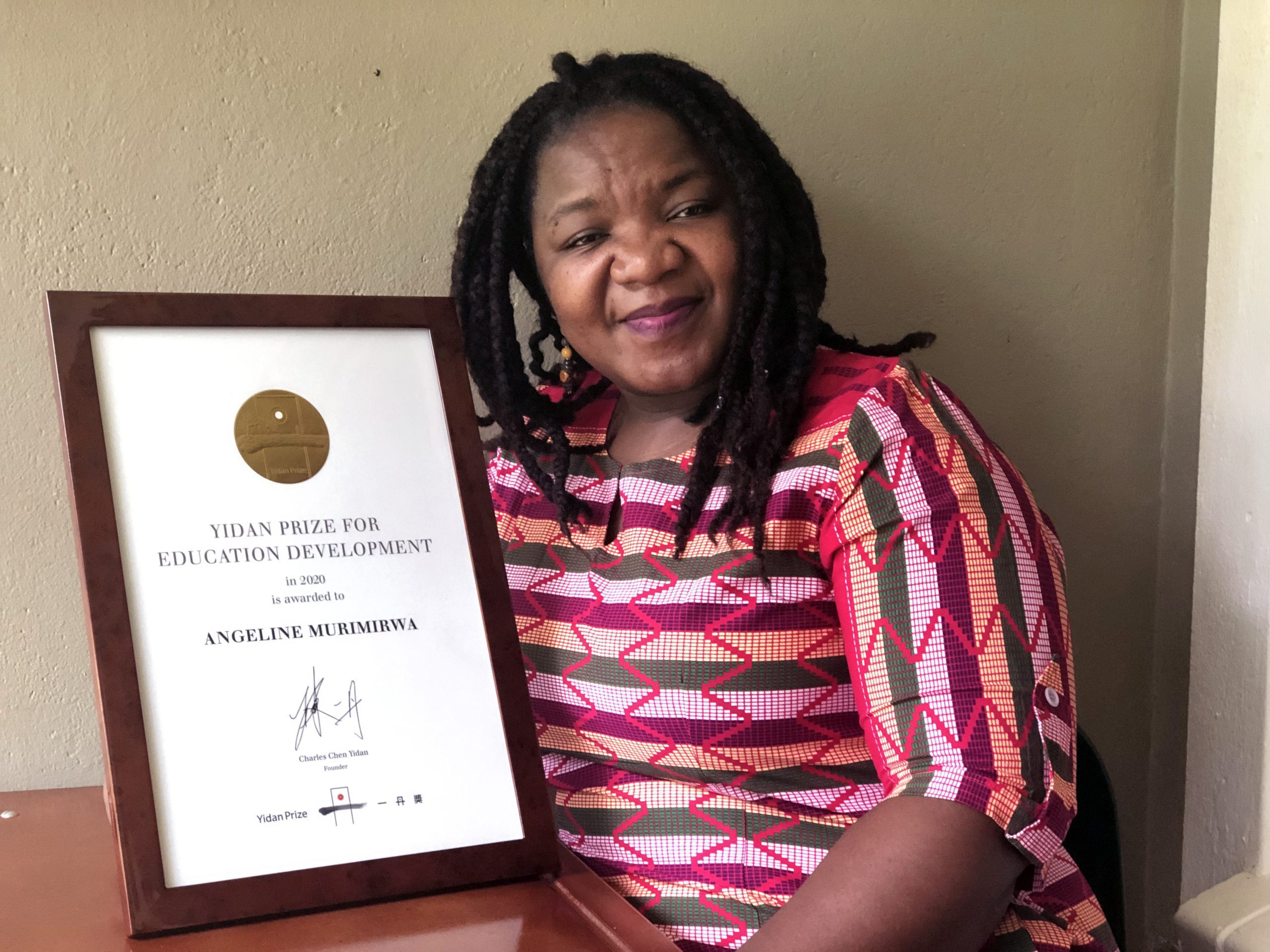 Angeline Murimirwa holding the Yidan Prize certificate