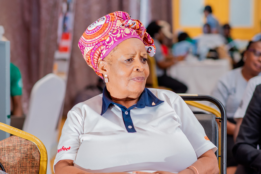 Ida Deleza wearing a polo shirt and a CAMFED Association patterned print head-scarf.